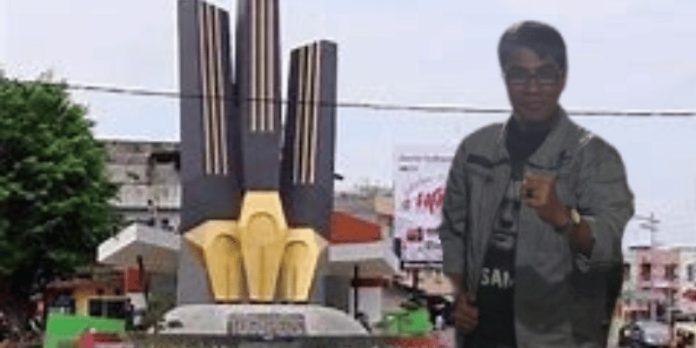 Mahmud Marhaba dengan latar belakang Tugu Pers di Kota Jambi.